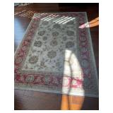 Area rug in colors of gold tan, and red