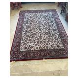 Area rug in colors of maroon, navy tan and cream