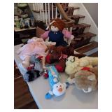 Group of dolls and stuffed animals with a couple of dog toys