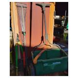 Grouping yard tools, loppers, 2 rakes, one expanding to get in-between bushes, small hand saw, and spreader