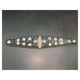 Black leather-like snap bracelet enhanced with multiple rhinestone accents and Fleur de Lis center