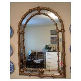 Regency-style gilt plastic framed mirror, inspired by the designs of Serge Roche, with a double-lined arch design and carved palm frond motifs…..33-1/4 x 49 tall