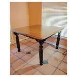 Farmhouse Style Tall Dining Table with turned legs. 36 1/4"T x 54 1/4"L x 57 3/4"W. Medium wood finish top, Black rubbed finish bottom & legs. There is a ring stain on top and scuffs on legs. Sturdy, 