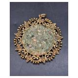 Vintage gold-tone ornate pendant featuring green jade-like chips….2-1/4” diameter