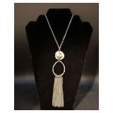 Long silver-tone necklace with silverplate hammered pendant and silver tone tassels