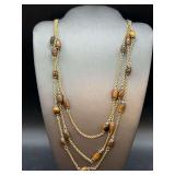 Elegant Monet gold tone triple strand necklace with tiger eye style beads