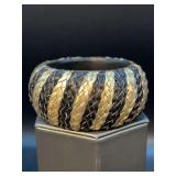 Wood handle bracket covered in black and gold braided leather-like material