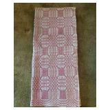 Full/Queen antique overshot coverlet, typically made of wool and cotton, featuring a pink and white geometric pattern. These coverlets are considered collectible items due to their historical signific