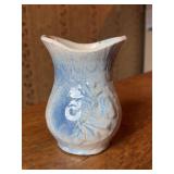 Antique primitive American stoneware vase featuring a blue and white salt glaze with a raised floral or Dutch-inspired embossed design…..5” tall and has age crack