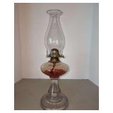 Vintage oil lamp featuring a clear glass pedestal base and a glass chimney