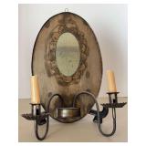 Vintage Pennsylvania Dutch wall sconce/mirror featuring a distressed oval mirror framed in metal with integrated candleholders, resembling a farmhouse look…..11w x 14 tall