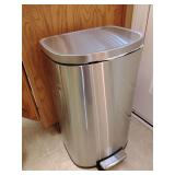Stainless steel step trash can, commonly used in kitchens or offices for hygienic, hands-free waste disposal. 
Design: Features a semi-round or rectangular shape designed to fit against walls or in co
