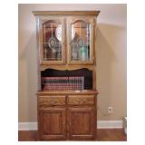 Solid oak two-part china hutch cabinet leaded glass doors and interior lighting, 2 drawers and double door compartment lower portion. 79' T x 39 1/2' W x 17 1/2' D. Other contents not included.