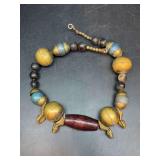Uniquely designed brass and wood beaded necklace with brass feet accents…..clasp needs repaired