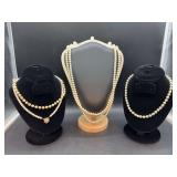 Grouping of white beaded necklaces of various lengths