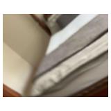 Grey queen size duvet cover with two matching shams, a knitted bed pillow, and grey queen size quilt.