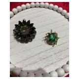 Two brooches; Green ladybug beetle brooch ￼and a black and gray brooch