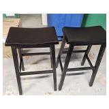 Two black saddle style bar stools. 16 x9 x 29 in tall.