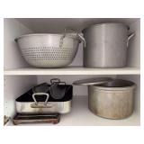 Contents of kitchen cabinet above oven…..large strainer, large stock pot, large roasting pan and more
