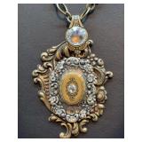 Beautiful vintage brass-tone decorative pendant necklace….pendant is accented with center locket and clear stones….top of pendant is a vintage spoon (see pics)