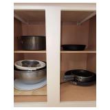 Contents of kitchen cabinet…..skillets, unmarked cast iron skillet and more