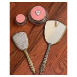 Vintage gilded vanity set with pink back and heart enclosed rose floral design…..includes mirror, brush and 2 powder jars (missing florals in smaller jar)
