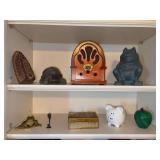 2 shelves of home decor…..battery powered radio, frogs, piggy bank, cast iron, marble apple with brass stem