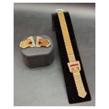 Vintage gold-tone buckle-style clip-on earrings and matching bracelet from the Retro period featuring woven mesh, rhinestone accents, and marquise-cut red stones -