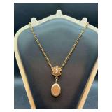 Vintage Victorian-style locket necklace featuring a cameo accent and an oval locket pendant