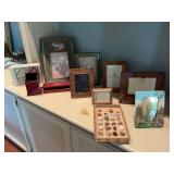 Grouping of picture frames with some rocks, minerals and desk supplies