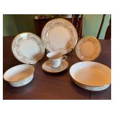 Seven piece Lenox Gold trimmed place setting. Castle Garden pattern.  Set includes a 10 7/8 inch dinner plate, 8 inch salad plate, 6 1/2 inch dessert plate, 7 1/2 and 5 1/2 inch bowls and a cup and sa
