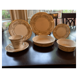 Seven piece Lenox Gold trimmed place setting. Castle Garden pattern.  Set includes a 10 7/8 inch dinner plate, 8 inch salad plate, 6 1/2 inch dessert plate, 7 1/2 and 5 1/2 inch bowls and a cup and sa