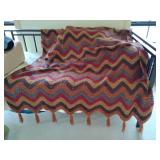 Handmade vintage-style crochet throw blanket,  featuring a zig-zag chevron ripple pattern in fall colors orange, brown, and red, tassels at both ends. Twin or Full
