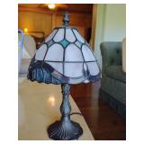 Small Tiffany-style accent/table lamp, stained glass shade with a geometric, baroque pattern in white and blue, bronze-finished metal base. 13" T x 7 3/4" across bottom of shade
