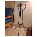 Wrought iron plant stand features a twisted tripod base, leaf motif details, and a top receptacle designed to hold a plant pot or fish bowl, 35" T x 18" W at feet.