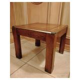 End table, mid-century modern, wood grain inlays, top edges trimmed and feet wrapped in brass tone metal, 16" T x 19 1/2" x 19 1/2". Some metal trim around top has small dings and a cigarette burn, se