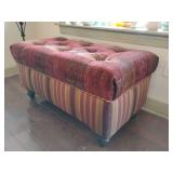 tufted, upholstered ottoman featuring a mixed-pattern fabric design with stripes on the sides and a tapestry-style pattern on the top, supported by low wooden feet, with storage under seat. 38" W x 20