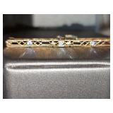 10 K Antique pin with light blue stones. 2 in wide.