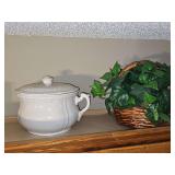Chamber pot with lid and wicker basket with greenery.