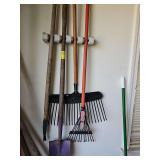 Rakes and shovel hanging on the wall. Wall hanger is not included.