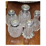 Grouping of cut glass salt or pepper shakers with sterling silver lids. 2.75 - 3.25 in tall.