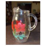 vintage clear glass beverage pitcher featuring painted red hibiscus flowers - 8” tall