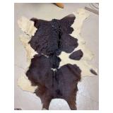 Natural cowhide rug featuring a distinctive brown or black and white pattern…..33-1/2 x 44-1/4…..some frayed edges
