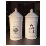 (2) 14” tall ceramic advertising canisters - 1 lid has crack and 1 has chip around rim of lid