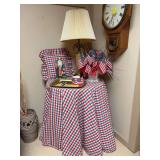 Round wooden table with custom red/white/blue table cover, patriotic home decor and matching reversible throw pillow…..26”D x 29-1/2” tall…..Lamp, clock and items on floor not included