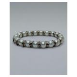 White cultured or high quality faux pearl stretch bracelet featuring silver-toned ring spacers between each pearl.