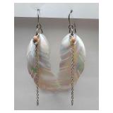 Handmade dangle earrings featuring carved mother of pearl seashell feather charms on silver-tone handmade dangle earrings featuring carved mother of pearl seashell feather charms on silver-tone hooks.