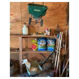 Two spreaders - a green thumb easy spreader, several bags of weed stop and miscellaneous lawn supplies as shown. Tools behind and beside spreaders are not included.