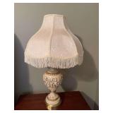 A vintage ceramic cherub and brass table lamp 7 1/2” x 30” with a fringed shade being an 18 inches wide