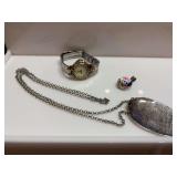 A necklace charm with bird and flowers, a Blessed necklace and a Peugeit Quartz watch